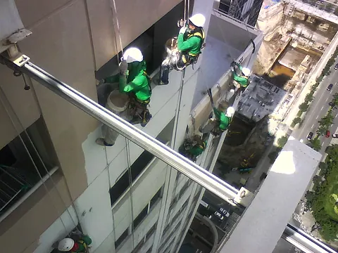 A painting crew working down the facade of a residential tower