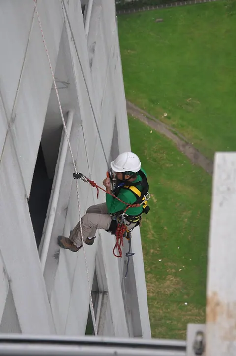 A technician on rope checking a facade close up